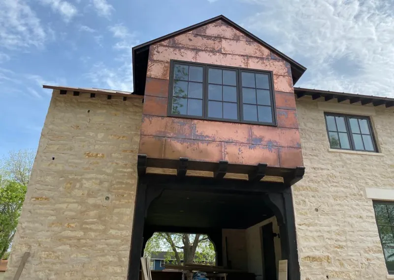 Copper metal panel facade on a stone building for Skylight Installation in Leavenworth
